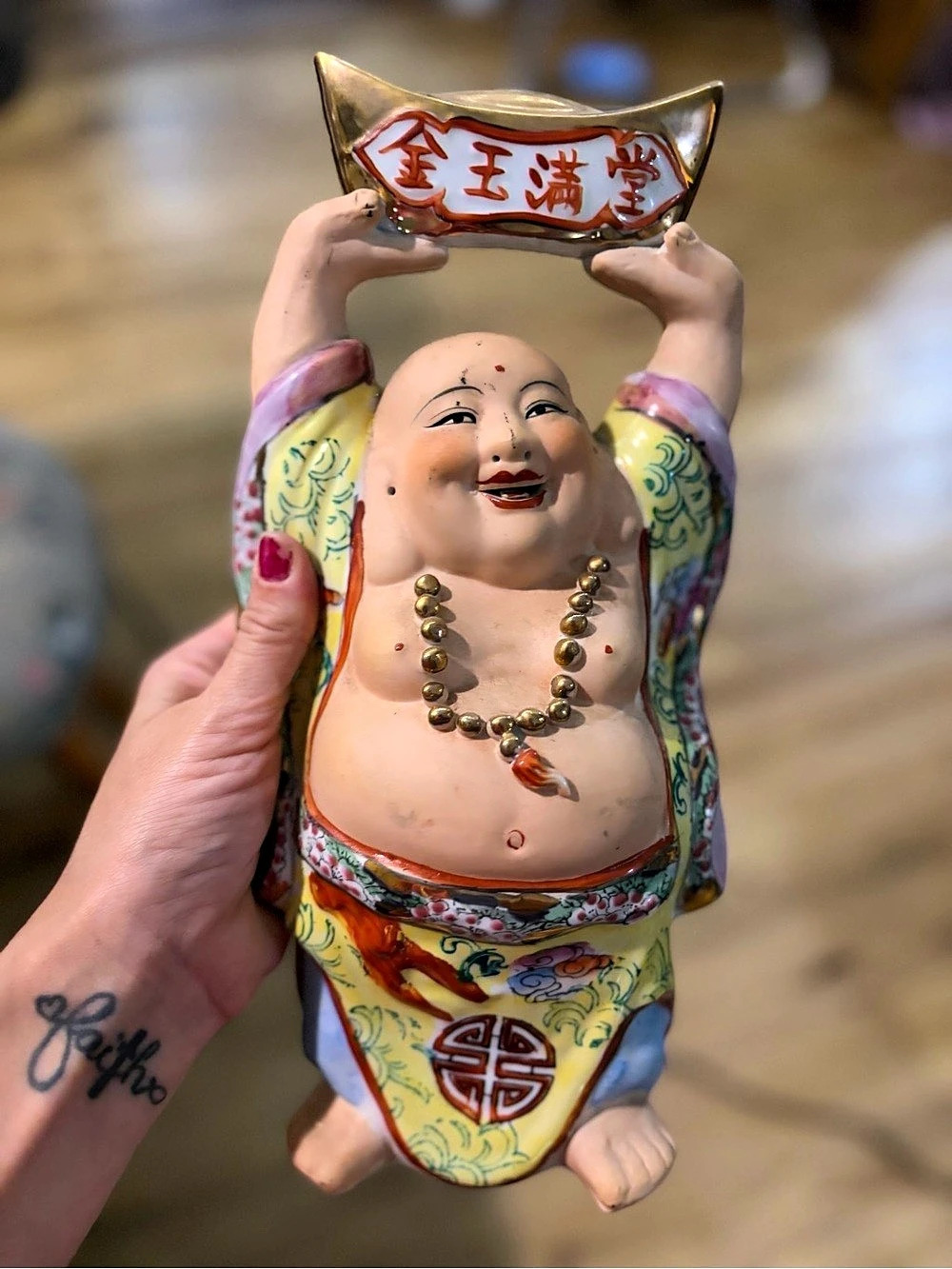 Vintage porcelain Laughing Buddha figurine wearing colorful, ornate robes and ho